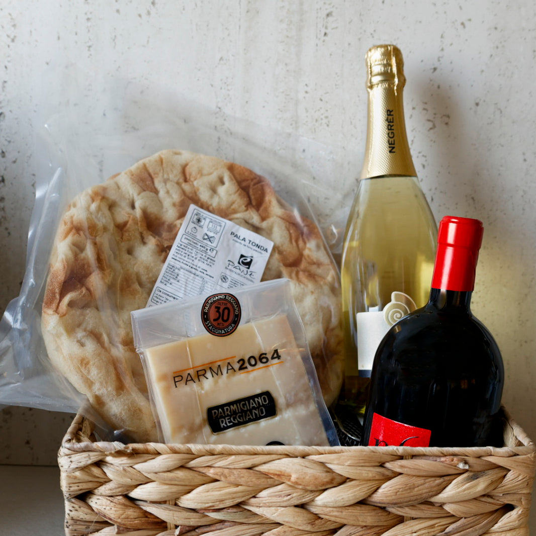 Gourmet Box von Saporitaly mit Kàse und Wein. Parmigiano Reggiano DOP 30 moante, pinsa "tonda", rotwein und metodo classico aus Italien